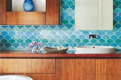 Foto de cuarto de baño principal actual de tamaño medio con bañera exenta, baldosas y/o azulejos en mosaico, lavabo sobreencimera, encimera de madera, baldosas y/o azulejos multicolor y suelo de piedra caliza