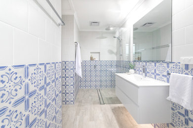 Inspiration för ett mellanstort funkis vit vitt badrum med dusch, med släta luckor, vita skåp, en öppen dusch, en toalettstol med hel cisternkåpa, flerfärgad kakel, keramikplattor, flerfärgade väggar, klinkergolv i porslin, ett integrerad handfat, flerfärgat golv och med dusch som är öppen