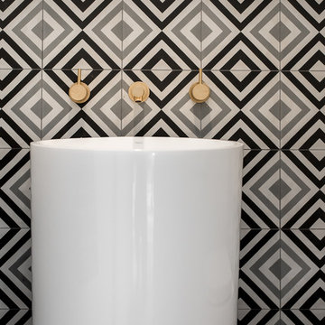 Encaustic patterned tiling & gold tapeware in powder room