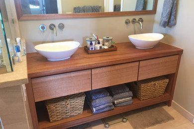 Medium sized rustic shower room bathroom in Other with flat-panel cabinets, medium wood cabinets, a vessel sink, wooden worktops, a two-piece toilet and beige walls.