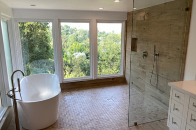 Example of a large minimalist master brown tile and porcelain tile porcelain tile, multicolored floor and double-sink bathroom design in Los Angeles with flat-panel cabinets, white cabinets, a two-piece toilet, white walls, an undermount sink, quartz countertops, white countertops and a freestanding vanity