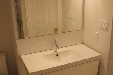 トロントにある小さなモダンスタイルのおしゃれな浴室 (壁付け型シンク、コーナー設置型シャワー、一体型トイレ	、白いタイル、セラミックタイル、大理石の床) の写真