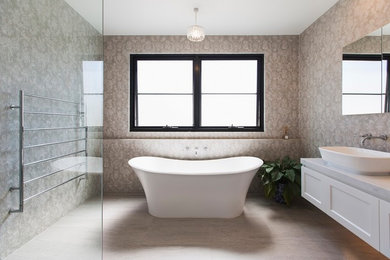На фото: большая главная ванная комната с фасадами в стиле шейкер, белыми фасадами, отдельно стоящей ванной, угловым душем, унитазом-моноблоком, розовой плиткой, керамической плиткой, розовыми стенами, полом из керамогранита, настольной раковиной, мраморной столешницей, серым полом, открытым душем и серой столешницей