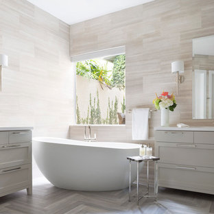 Inspiration for a large transitional master bathroom in Miami with an integrated sink, shaker cabinets, grey cabinets, quartzite benchtops, a freestanding tub, beige tile, limestone floors, limestone and grey floor.