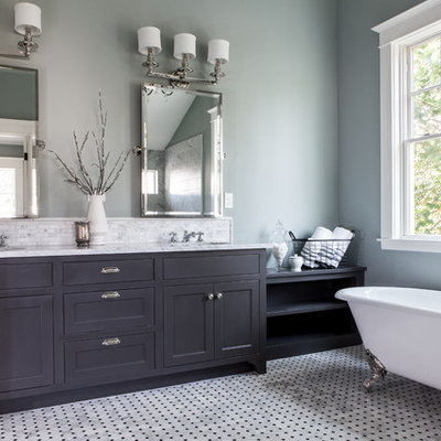 Example of a classic claw-foot bathtub design in Portland with shaker cabinets