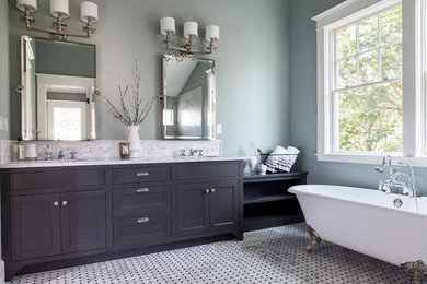 Example of a classic claw-foot bathtub design in Portland with shaker cabinets