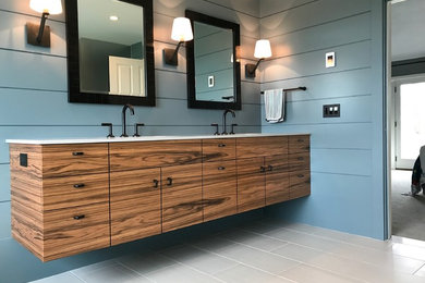 Mid-sized trendy master porcelain tile and gray floor bathroom photo in Boston with blue walls, an undermount sink, a hinged shower door, flat-panel cabinets, medium tone wood cabinets and solid surface countertops