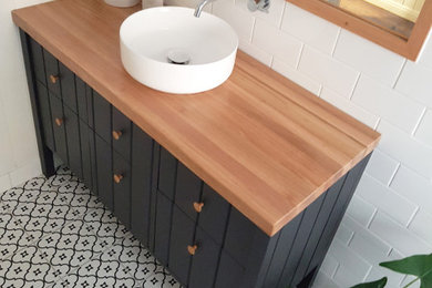 Mid-sized transitional white tile and ceramic tile porcelain tile, white floor and single-sink bathroom photo in Brisbane with black cabinets, white walls, a vessel sink, wood countertops, a hinged shower door and a freestanding vanity