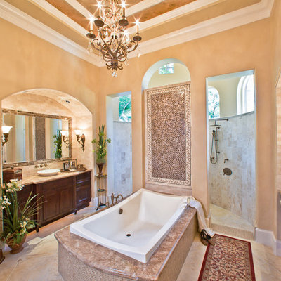 Example of a large classic master beige tile and stone tile beige floor bathroom design in Houston with a vessel sink, dark wood cabinets, a one-piece toilet, recessed-panel cabinets and beige walls