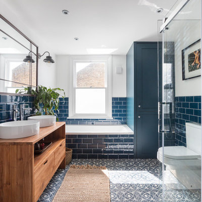 Mid-sized transitional kids' blue tile and subway tile cement tile floor and multicolored floor bathroom photo in London with flat-panel cabinets, medium tone wood cabinets, a two-piece toilet, white walls, a vessel sink, wood countertops and brown countertops