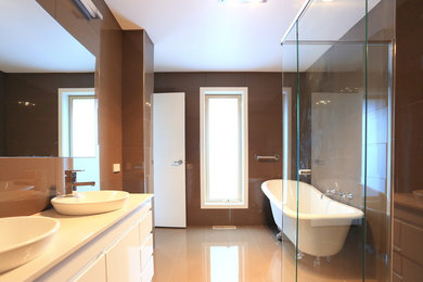 Exemple d'une salle de bain principale moderne de taille moyenne avec une vasque, un placard à porte plane, des portes de placard blanches, un plan de toilette en quartz modifié, une baignoire sur pieds, une douche d'angle, un carrelage marron, des carreaux de porcelaine, un mur marron et un sol en carrelage de porcelaine.