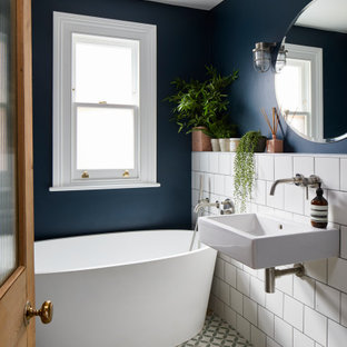 Medium sized contemporary shower room bathroom in London with a freestanding bath, blue walls, mosaic tile flooring, a wall-mounted sink and multi-coloured floors.
