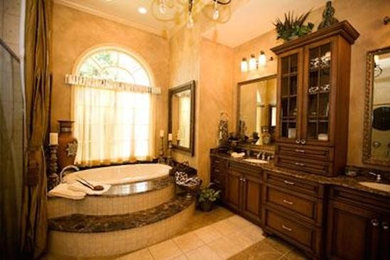 Drop-in bathtub - large drop-in bathtub idea in DC Metro with dark wood cabinets, granite countertops and beige walls