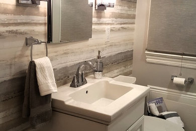 Mid-sized transitional gray tile and porcelain tile porcelain tile and gray floor alcove bathtub photo in New York with raised-panel cabinets, white cabinets, gray walls and an integrated sink