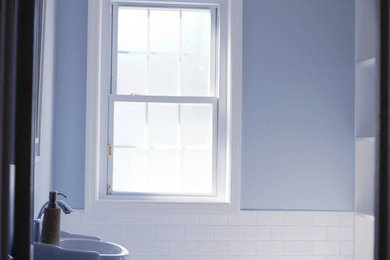 Kleines Klassisches Badezimmer mit Toilette mit Aufsatzspülkasten, blauer Wandfarbe, Porzellan-Bodenfliesen und Sockelwaschbecken in New York