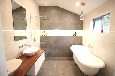 Modernes Badezimmer En Suite mit hellbraunen Holzschränken, Löwenfuß-Badewanne, Nasszelle, Wandtoilette, Keramikfliesen, Zementfliesen für Boden und Waschtisch aus Holz in Brisbane