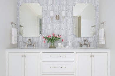 Bathroom - transitional gray tile and marble tile white floor and double-sink bathroom idea in Little Rock with recessed-panel cabinets, white cabinets, white walls, an undermount sink and white countertops