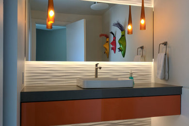 シアトルにあるコンテンポラリースタイルのおしゃれな浴室 (フラットパネル扉のキャビネット、オレンジのキャビネット、白いタイル、白い壁、コンクリートの床、ベッセル式洗面器、グレーの床、グレーの洗面カウンター) の写真