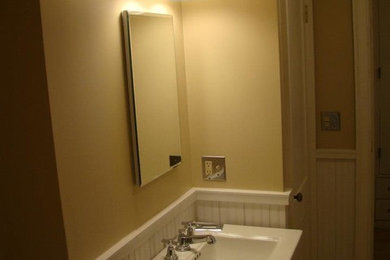 Foto de cuarto de baño tradicional de tamaño medio con lavabo tipo consola, puertas de armario blancas, paredes amarillas y aseo y ducha
