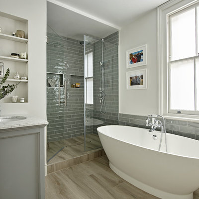 Beach style 3/4 gray tile beige floor bathroom photo in London with gray cabinets, white walls, an undermount sink, a hinged shower door and gray countertops