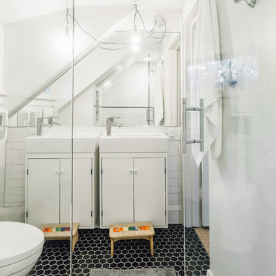 Example of a small trendy kids' black and white tile and porcelain tile porcelain tile alcove shower design in Minneapolis with furniture-like cabinets, white cabinets, a two-piece toilet, gray walls and a wall-mount sink