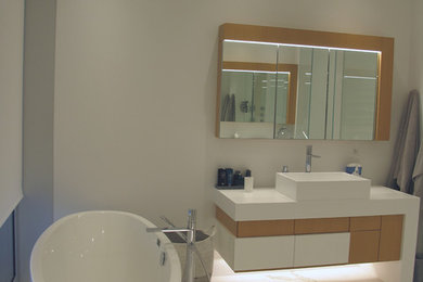 Idéer för att renovera ett stort funkis en-suite badrum, med ett fristående badkar, släta luckor, skåp i mellenmörkt trä, vita väggar, marmorgolv, ett fristående handfat, bänkskiva i kvarts och vitt golv