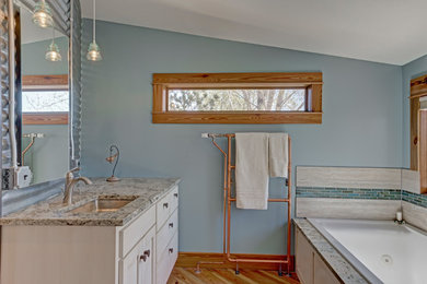 Bathroom - mid-sized farmhouse master medium tone wood floor and brown floor bathroom idea in Denver with shaker cabinets, white cabinets, a two-piece toilet, blue walls, an undermount sink and granite countertops