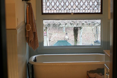 リトルロックにあるカントリー風のおしゃれな浴室 (磁器タイル、青い壁、磁器タイルの床、猫足バスタブ、マルチカラーのタイル) の写真