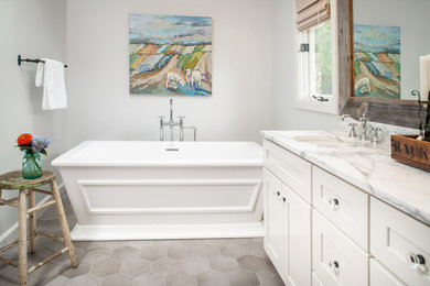 Exempel på ett mellanstort lantligt vit vitt en-suite badrum, med skåp i shakerstil, vita skåp, ett fristående badkar, en dusch i en alkov, vit kakel, keramikplattor, vita väggar, klinkergolv i porslin, ett undermonterad handfat, marmorbänkskiva, grått golv och dusch med gångjärnsdörr