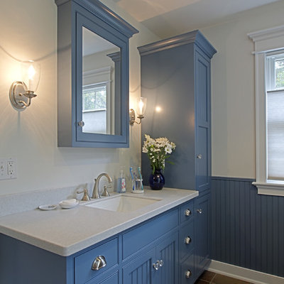 Inspiration for a mid-sized craftsman slate floor drop-in bathtub remodel in Philadelphia with shaker cabinets, blue cabinets, white walls, an undermount sink and solid surface countertops