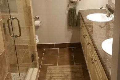 Alcove shower - mid-sized traditional master brown tile and ceramic tile ceramic tile alcove shower idea in Detroit with recessed-panel cabinets, beige cabinets, a one-piece toilet, beige walls, a drop-in sink and quartzite countertops