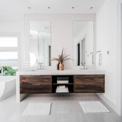Freestanding bathtub - contemporary white tile gray floor freestanding bathtub idea in Seattle with flat-panel cabinets, dark wood cabinets, white walls, an undermount sink and white countertops