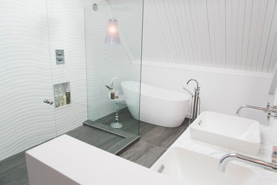 バンクーバーにあるモダンスタイルのおしゃれな浴室 (オーバーカウンターシンク、御影石の洗面台、置き型浴槽、ダブルシャワー、白いタイル、セラミックタイル、白い壁、セラミックタイルの床) の写真