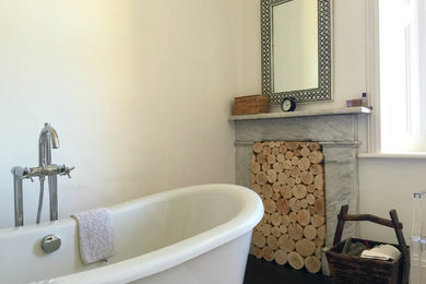 Réalisation d'une salle de bain minimaliste avec une baignoire indépendante et un mur blanc.