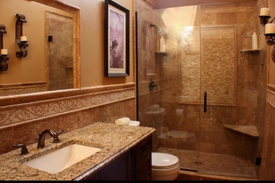 Example of a mid-sized tuscan 3/4 ceramic tile beige floor alcove shower design in New York with recessed-panel cabinets, dark wood cabinets, a two-piece toilet, beige walls, an undermount sink, granite countertops and a hinged shower door