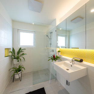 Photo of a small contemporary bathroom in Canberra - Queanbeyan with glass-front cabinets, a curbless shower, yellow tile, ceramic tile, white walls, cement tiles, a wall-mount sink, grey floor and an open shower.