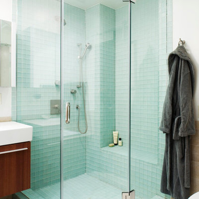 Mid-sized eclectic master blue tile and glass tile ceramic tile bathroom photo in New York with flat-panel cabinets, dark wood cabinets, white walls, a wall-mount sink and solid surface countertops