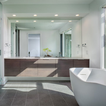 Floating gray vanity with large mirror and Kohler freestanding "Purist" tub