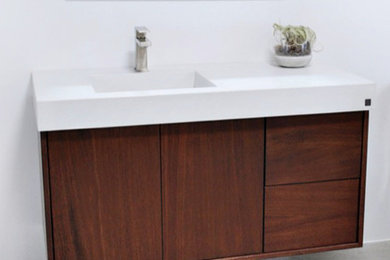 Trendy bathroom photo in Seattle with recessed-panel cabinets, medium tone wood cabinets, a wall-mount sink, concrete countertops and white countertops