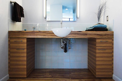 Contemporary bathroom in Phoenix with flat-panel cabinets, medium wood cabinets, white tiles, porcelain tiles, bamboo flooring and wooden worktops.
