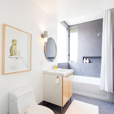 Example of a trendy gray tile bathroom design in Atlanta with flat-panel cabinets, medium tone wood cabinets, a one-piece toilet and white walls