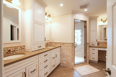 Example of a mid-sized classic master beige tile and subway tile porcelain tile corner shower design in Cincinnati with an undermount sink, raised-panel cabinets, white cabinets, quartz countertops and beige walls