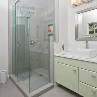 Immagine di una stanza da bagno tradizionale con lavabo a bacinella, ante verdi, doccia alcova e piastrelle grigie