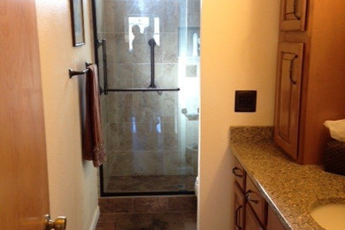 Example of a small classic 3/4 brown tile and porcelain tile porcelain tile double shower design in Sacramento with raised-panel cabinets, medium tone wood cabinets, quartz countertops, a one-piece toilet, an undermount sink and beige walls