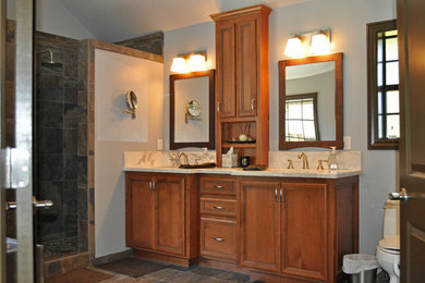 Ejemplo de cuarto de baño principal con puertas de armario de madera oscura y encimera de mármol