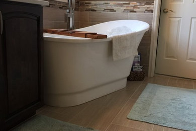 Small arts and crafts master beige tile and ceramic tile ceramic tile and beige floor bathroom photo in Boise with raised-panel cabinets, dark wood cabinets, a two-piece toilet, brown walls, a drop-in sink, quartzite countertops, a hinged shower door and white countertops