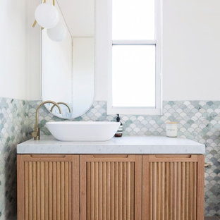 Ejemplo de cuarto de baño actual con armarios con puertas mallorquinas, puertas de armario beige, baldosas y/o azulejos grises, baldosas y/o azulejos en mosaico, paredes blancas, lavabo sobreencimera, suelo gris y encimeras blancas
