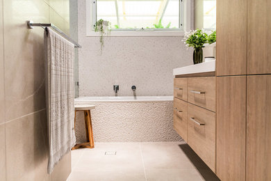 Idées déco pour une salle de bain principale contemporaine en bois brun de taille moyenne avec un placard à porte plane, une baignoire posée, un espace douche bain et un lavabo intégré.
