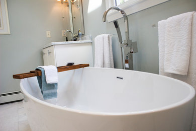Freestanding bathtub - mid-sized coastal master marble floor and beige floor freestanding bathtub idea in Boston with flat-panel cabinets, white cabinets, a two-piece toilet, gray walls, a drop-in sink and granite countertops