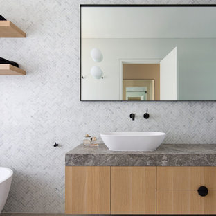 Photo of a mid-sized contemporary master bathroom in Sydney with flat-panel cabinets, brown cabinets, a freestanding tub, a corner shower, gray tile, marble, grey walls, a vessel sink, an open shower and grey benchtops.